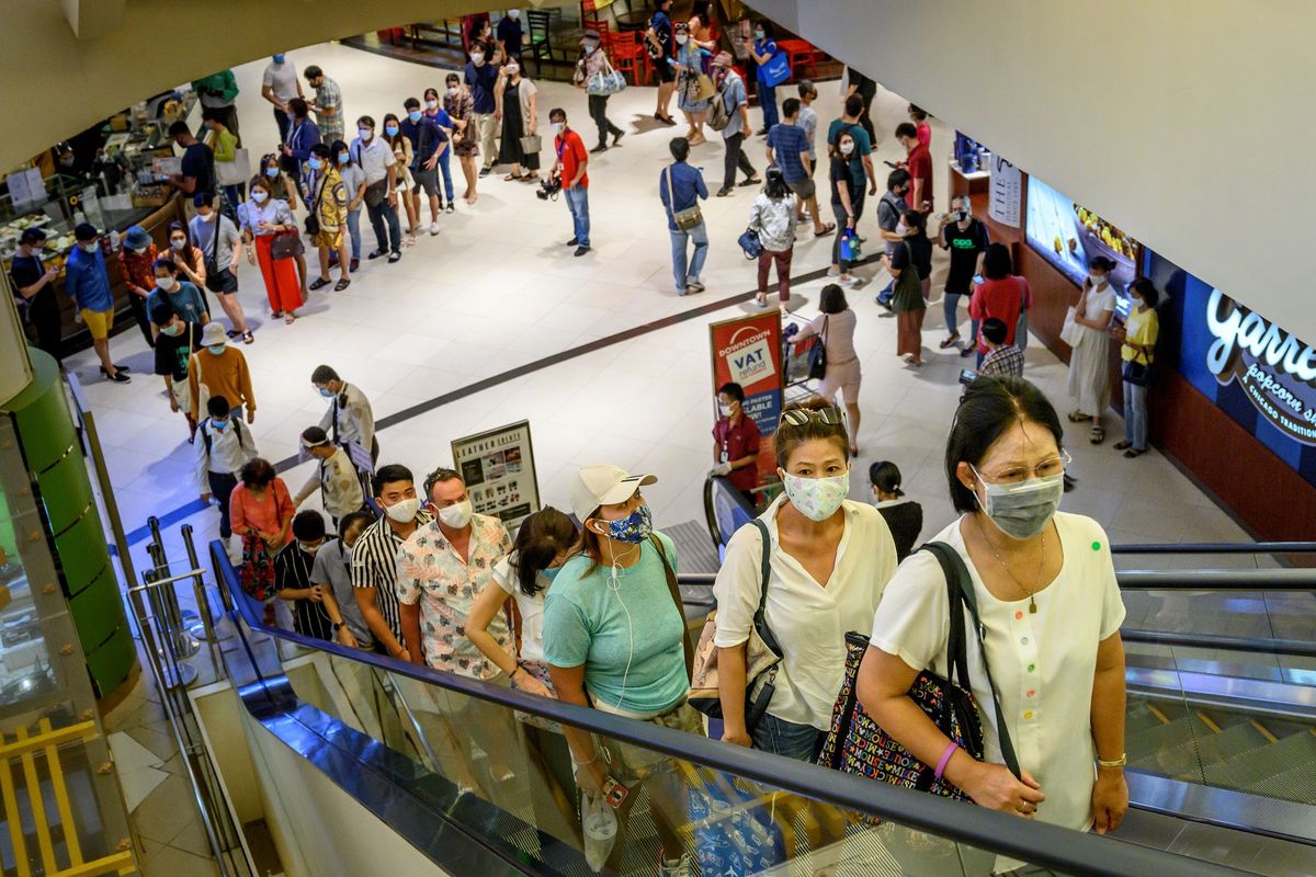 Pengunjung mengantre untuk menaiki eskalator di mal Siam Paragon, Bangkok, Thailand, Minggu (17/5/2020). Mal-mal di Thailand dibuka lagi setelah angka penularan Covid-19 melambat.