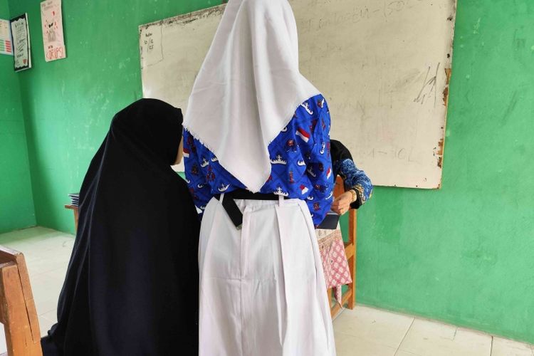 ilustrasi: Seorang ibu mengambil rapor anaknya di sekolah, potret dominasi peran ibu dalam urusan pendidikan anak.