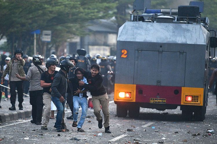 Polisi mengamankan pendemo yang rusuh di Jalan KS Tubun, Jakarta, Rabu (22/5/2019). Bentok terjadi setelah massa dipukul mundur dari kericuhan di Tanah Abang, Jakarta Pusat, Selasa (21/5/2019) malam.