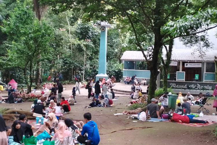 Sejumlah pengunjung ketika botram atau makan bersama usai lelah berkeliling di Kebun Binatang Bandung, Kota Bandung, Jawa Barat, Kamis (11/4/2024).