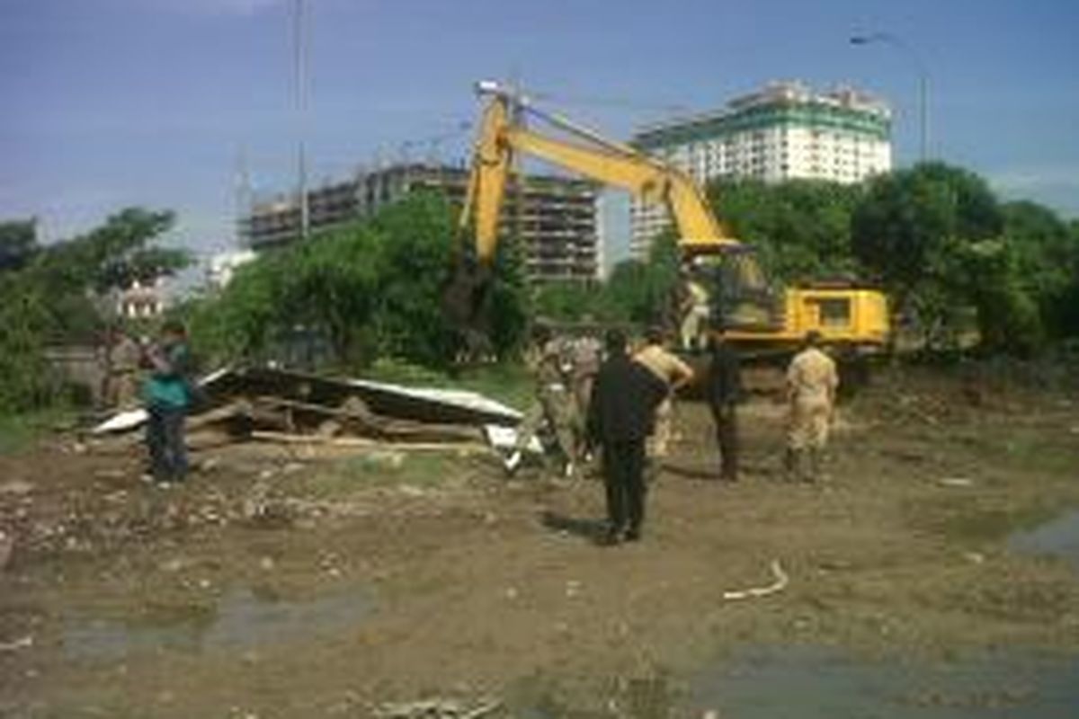 Penertiban bangunan liar kembali dilakukan di RW 16 Pejagalan, Penjaringan Jakarta Utara, Rabu (23/4/2014). Lahan ini seharusnya menjadi lokasi embung (penampungan air). Tak kunjung terealisasinya embung tersebut menjadi pemicu penyalahgunaan lahan kosong ini menjadi lahan parkir kontainer dan bangunan liar. 