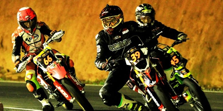 Ketiga pebalap supermoto sedang memasuki tikungan pada balapan Trail Game Asphalt di Sirkuit Mijen Semarang, April 2018