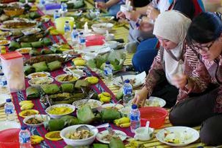 Makan bersama para ibu Dharma Wanita Persatuan (DWP) Kabupaten Kutai Barat di Lamin Melayu di Taman Budaya Sendawar, Kutai Barat, Kalimantan Timur, Senin (4/11/2013). Makanan yang dihidangkan berupa nasi sobo’t dengan lauk ikan patin bakar.