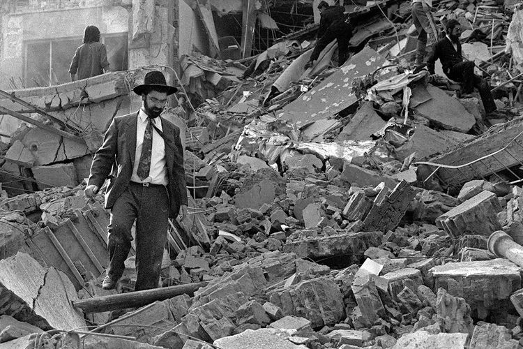 Foto dokumen bertanggal 18 Juli 1994, menunjukkan seorang pria berjalan di atas puing-puing pusat Yahudi di Buenos Aires, Argentina, yang hancur akibat ledakan bom Hezbollah.