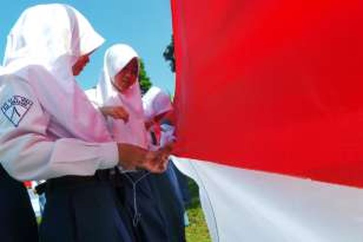 Ribuan pelajar di Bandungan, Kabupaten Semarang menjahit bendera merah putih sepanjang 71 meter di lapangan Jetis, Bandungan, Rabu (17/8/2016).