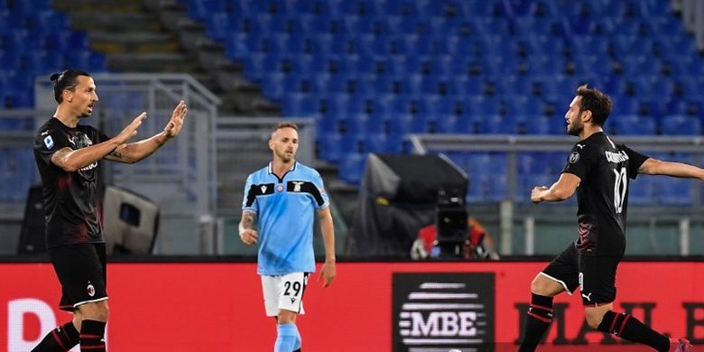 Playmaker AC Milan Hakan Calhanoglu melakukan selebrasi dengan Zlatan Ibrahimovic usai mencetak gol ke gawang Lazio pada lanjutan pekan ke-30 Liga Italia di Stadion Olimpico, Roma, Minggu (5/7/2020) dini hari WIB. 
