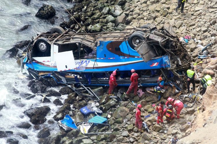 Ppetugas penyelamat, polisi dan petugas pemadam kebakaran berada di tempat kejadian setelah sebuah bus jatuh dari atas sebuah tebing, setelah bertabrakan dengan truk di jalan raya pesisir dekat Pasamayo, sekitar 45 km sebelah utara Lima, Peru, Selasa (2/1/2018). (Andina via AFP)