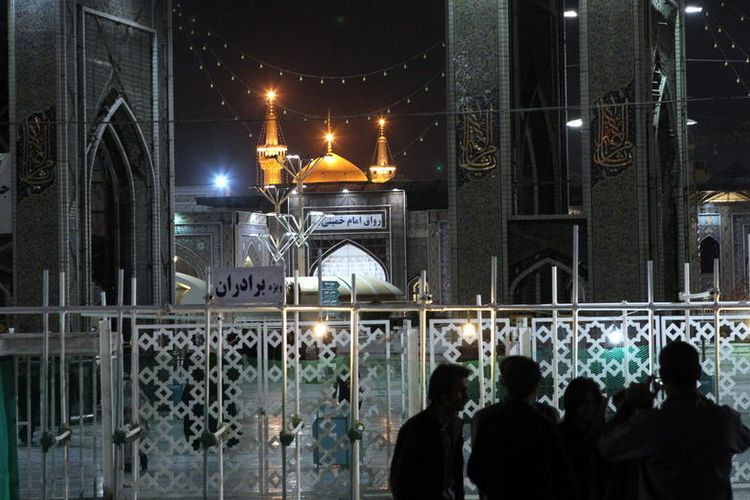 Pengunjung berdiri di luar Makam Suci Imam Reza di Mashhad, Iran. Saat virus corona merebak di Iran, situs ini ditutup.