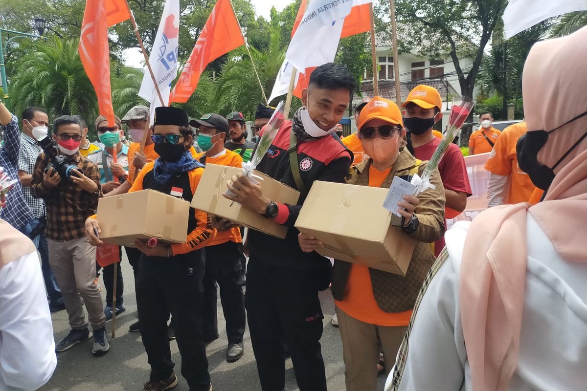 Para pengunjuk rasa mendapatkan paket sembako yang dibagikan oleh Polda Metro Jaya saat aksi demo di depan Gedung KPU, Minggu (1/5/2022).