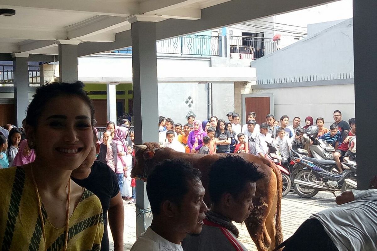 Ayu Ting Ting saat membelakangi warga yang datang untuk menyaksikan pemotongan hewan kurban di rumahnya, Depok, Jawa Barat, Jumat (1/8/2017).