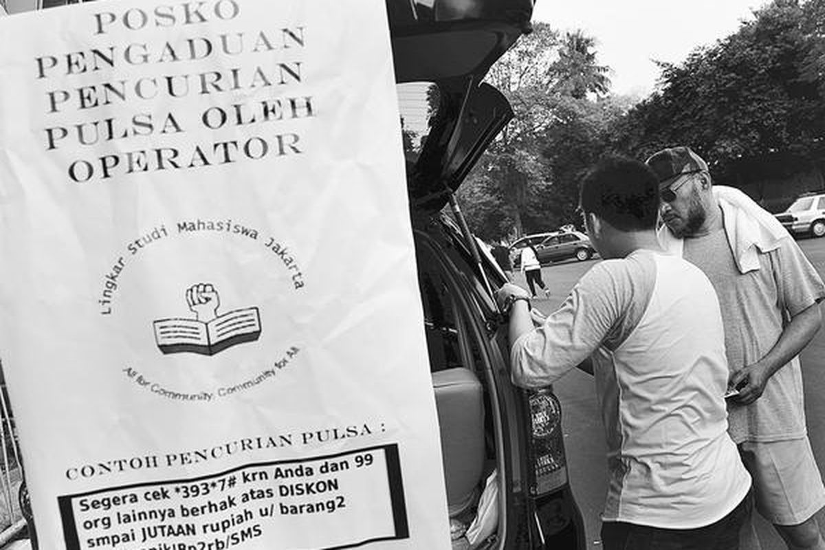 Dani (kiri) dari Lingkar Studi Mahasiswa Jakarta mencatat keluhan warga seputar hilangnya pulsa telepon tanpa sebab saat membuka posko keliling pengaduan pencurian pulsa oleh operator telekomunikasi di Gelora Bung Karno, Jakarta Pusat, Minggu (2/10).