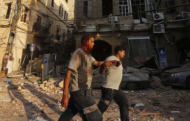 Seorang pria yang terluka dibantu saat berjalan melewati puing-puing di distrik Gemmayzeh, Beirut, Lebanon, usai terjadinya ledakan susulan, Selasa (4/8/2020). Sebanyak 73 orang tewas dan ribuan lainnya dilaporkan terluka dari insiden dua ledakan besar yang mengguncang Beirut tersebut.