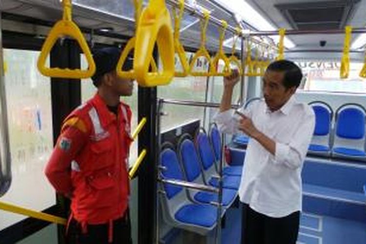 Gubernur DKI Jakarta Joko Widodo (kanan) berbincang dengan petugas bus transjakarta ketika ia menjajal operasional perdana bus baru tersebut, Rabu (15/1/2014).