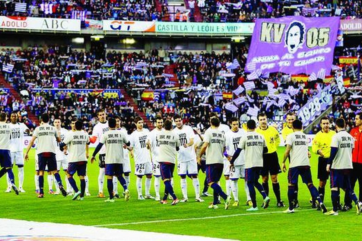 Para pemain Barcelona (membelakangi lensa) dan pemain  Valladolid, mengenakan kaus bertuliskan dukungan untuk Pelatih Barcelona Tito Vilanova, bersalaman sebelum laga Liga Spanyol antarkedua tim di Stadion  Jose Zorilla, Valladolid, Sabtu (22/12). Barcelona berpeluang besar menjuarai Liga Spanyol 2012-2013. 
