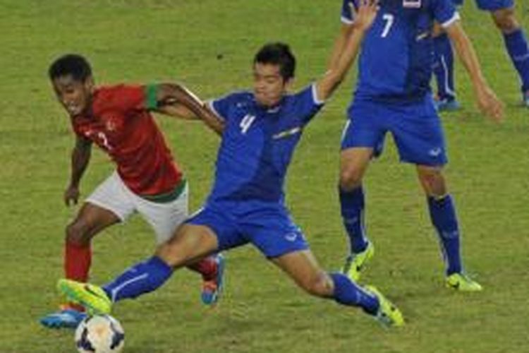 Gelandang tim nasional Indonesia U-23, Ramdani Lestaluhu (kiri), berupaya mempertahankan bola dari kawalan pemain Thailand, Sakolwat Skollah (kanan), pada laga final sepak bola putra SEA Games 2013 di Stadion Zayyarthiri, Naypyidaw, Sabtu (21/12/2013).