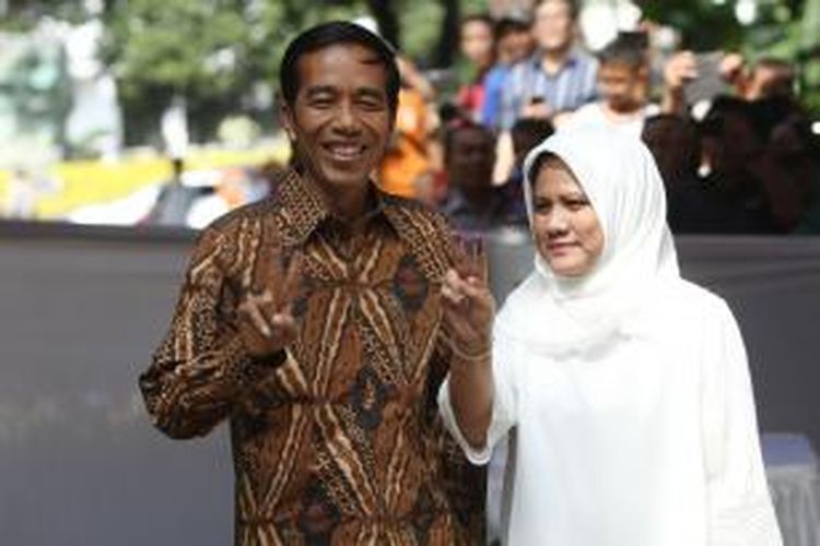 Calon Presiden nomor urut 1, Joko Widodo (Jokowi) bersama istrinya, Iriana, menunjukkan dua jari usai menyoblos di TPS 18 Menteng Jakarta Pusat, Rabu (9/7/2014). Pemilihan presiden serentak dilakukan di seluruh Indonesia dilakukan satu putaran. TRIBUNNEWS/HERUDIN