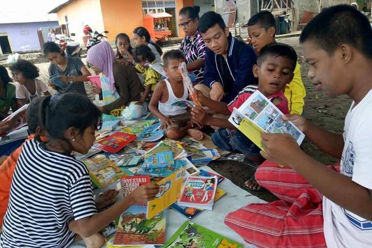 Beberapa orang anak tampak serius membaca buku kesukaannya saat Rumah Baca Barakate, Komunitas Hikayat Tanah Hitu, membuka lapak baca di sebuah tanah lapang di Desa Hitu Mesing, Kecamatan Leihitu, Kabupaten Maluku Tengah, Minggu, (30/5/2017).