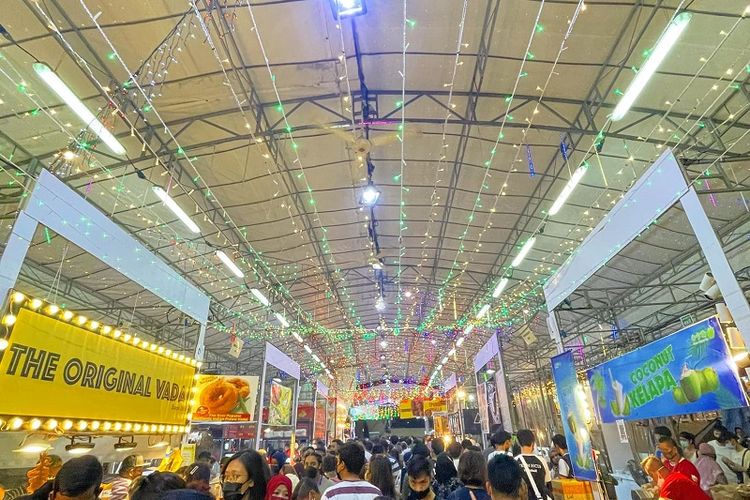 Pengunjung berjalan di tengah sesaknya kerumunan yang melihat-lihat kios makanan Bazaar Ramadhan Singapura 2022. Singapura kembali menggelar bazaar Ramadhan setelah meniadakannya pada tahun 2020 dan 2021 karena pandemi Covid-19
