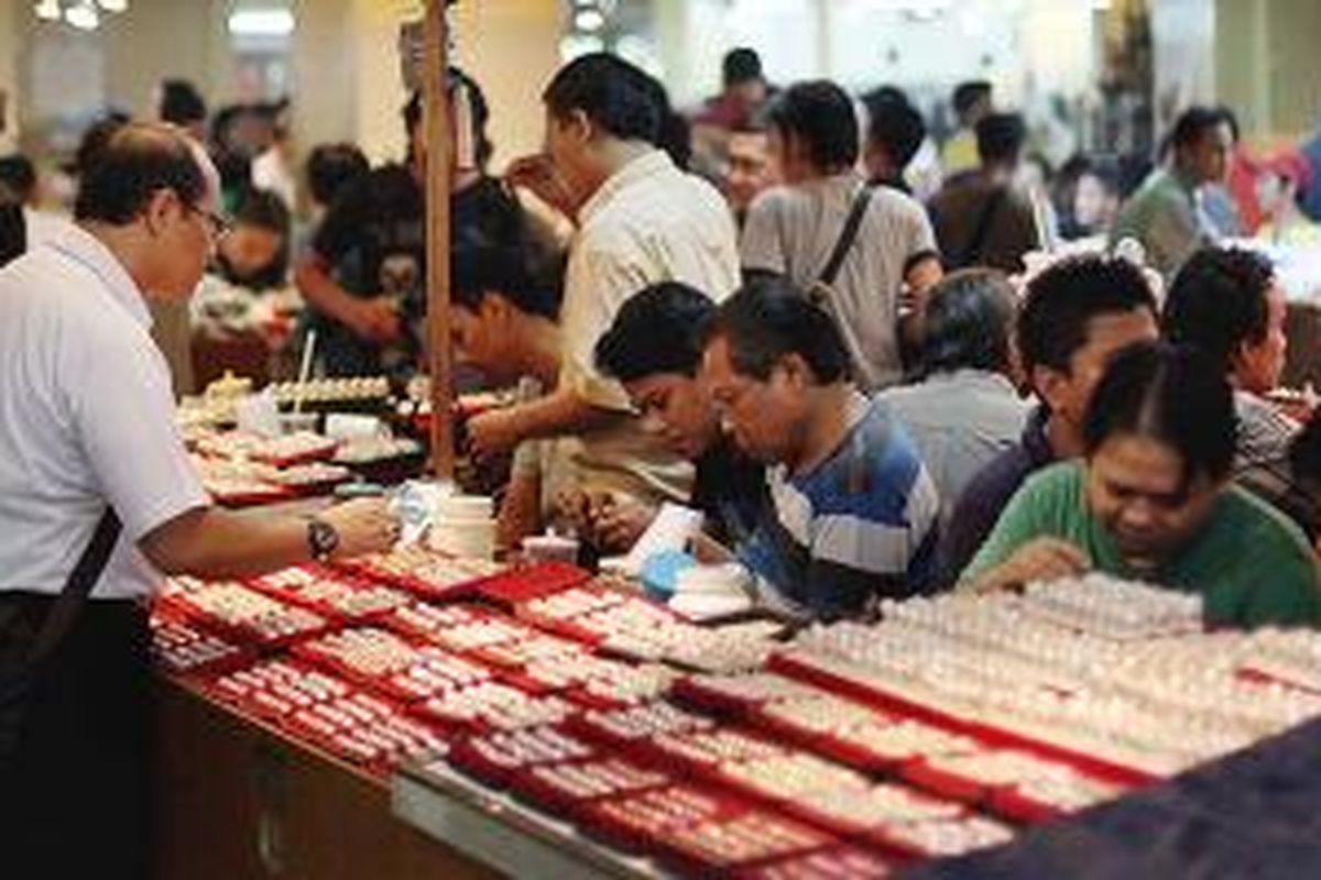 Pencinta batu akik berbelanja di Pasar Rawa Bening, Jakarta Timur, Selasa (18/11/2014). Pasar khusus batu batuan ini menjual aneka batu perhiasan dari mulai harga Rp 10.000 hingga jutaan rupiah.