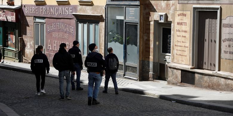 Polisi Perancis berpatroli di jalanan sembari melihat toko di Distrik Montmartre, Paris, sebagai bagian dari penegakan lockdown untuk  memerangi virus corona pada 25 Maret 2020.