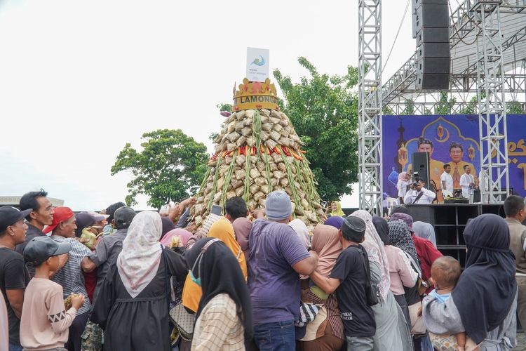 Warga berebut gunungan ketupat saat Festival Kupatan Tanjung Kodok 2024 di halaman parkiran Wisata Bahari Lamongan (WBL), Rabu (17/4/2024).