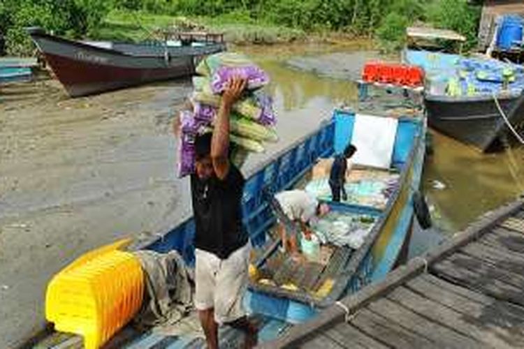 Suasana bongkar muatan perahu di Dermaga Lalo Salo, Pulau Sebatik, Nunukan, Kalimantan Utara, Rabu (21/12/2016). Sekitar 70 persen kebutuhan warga Sebatik didatangkan dari Tawau, Malaysia. Barang-barang ini masuk secara ilegal, dan kondisi ini sudah berlangsung bertahun-tahun.