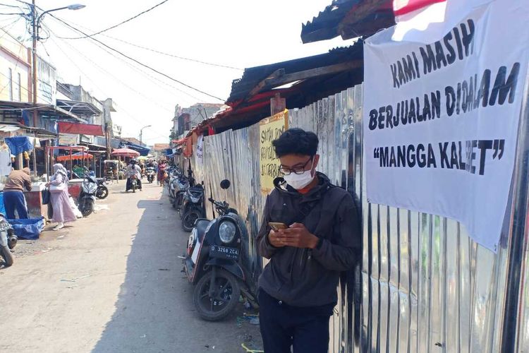 Bendera setenga tiang dan beberapa pamflet penolakan proses revitalisasi Pasar Banjaran, Kabupaten Bandung, Jawa Barat terpasang di pagar seng yang mengelilingi kios lama, pada Jumat (16/6/2023)