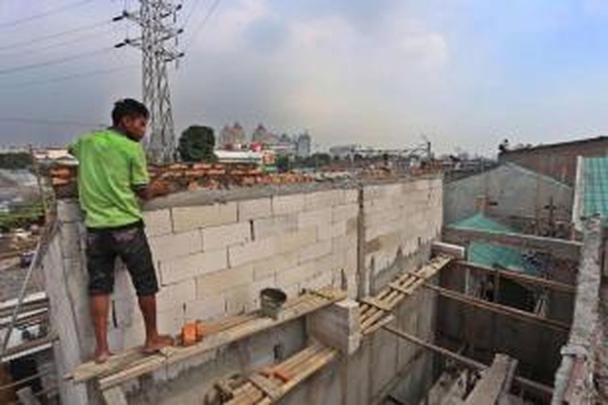 Pekerja menyelesaikan pembangunan Kampung Deret di Jalan Tanah Tinggi I RT 14 RW 01, Johar Baru, Jakarta Pusat, Selasa (2/7/2013). Kampung deret digagas Gubernur DKI Jakarta Joko Widodo.