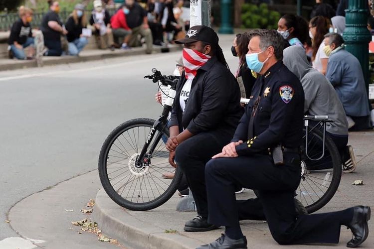 Polisi di Santa Cruz berlutut di tengah demonstran, sebagai bentuk dukungan atas protes kematian George Floyd. Foto ini diunggah Twitter @SantaCruzPolice pada Minggu (31/5/2020).