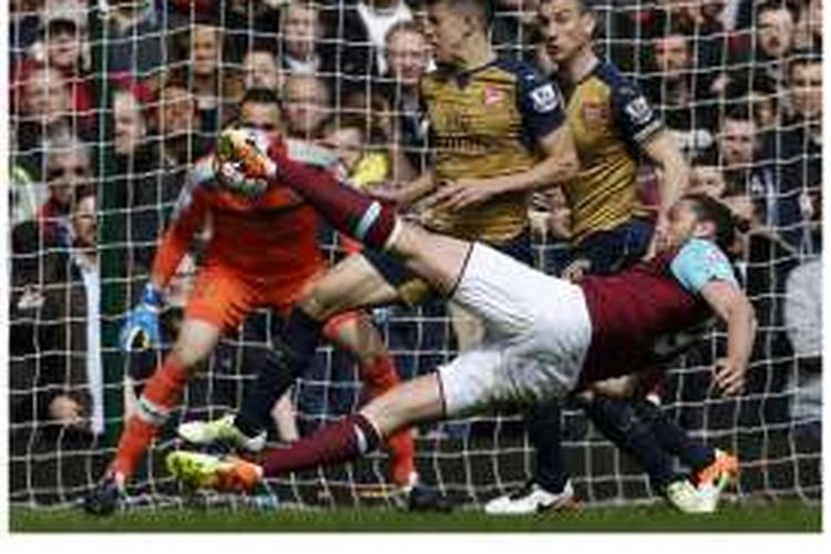 Striker West Ham United, Andy Carroll (kanan), melepaskan tendangan yang menghasilkan gol saat melawan Arsenal di The Boleyn Ground pada lanjutan Premier League, Sabtu (9/4/2016).