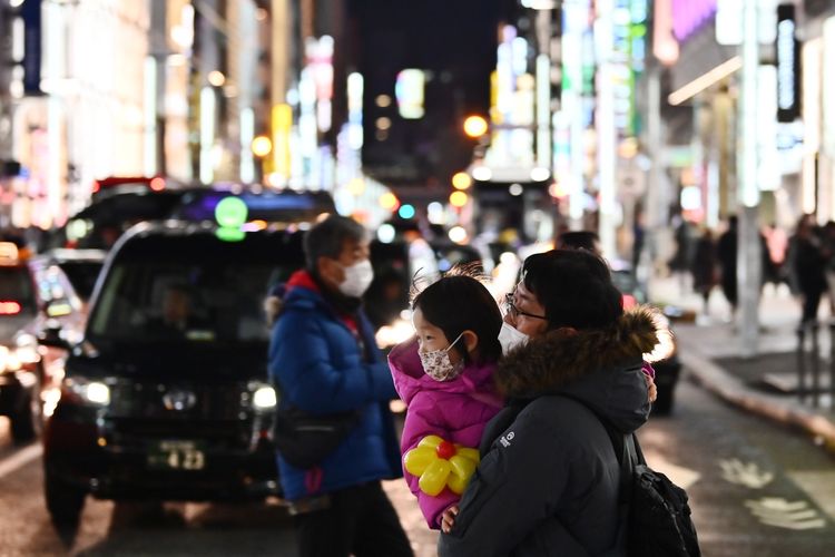 Pejalan kaki di Ginza, Tokyo, mengenakan masker untuk mencegah penyebaran virus Corona yang berasal dari Kota Wuhan, China, 25 Januari, 2020.

