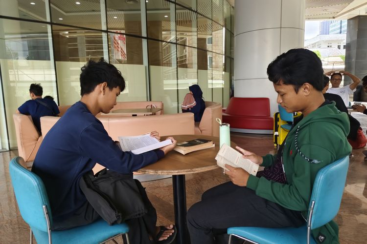 Evan (kiri) dan Hafiz (kanan), dua pelajar SMK kelas 12 asal Bekasi yang mengisi libur ke Perpustakaan Nasional, Jakarta Pusat, Minggu (9/2/2025). 