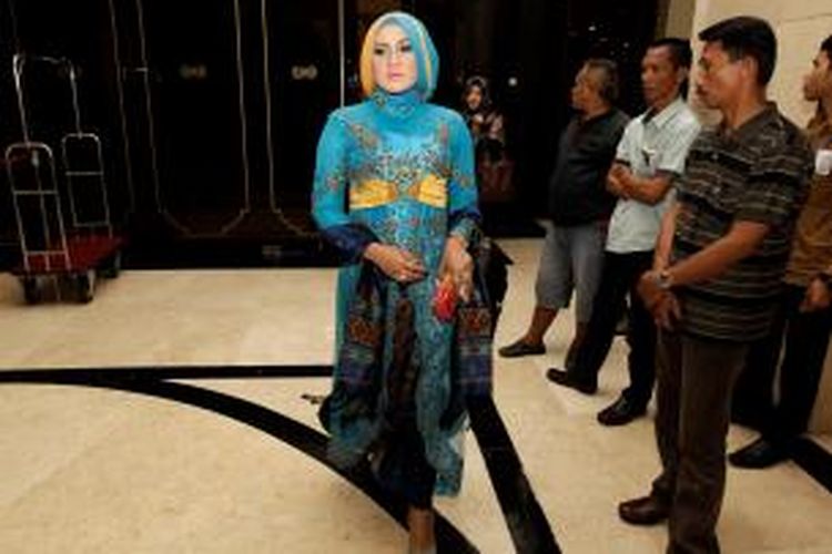 Seorang anggota DPR terpilih mengenakan kebaya panjang yang dipadu dengan kain songket.