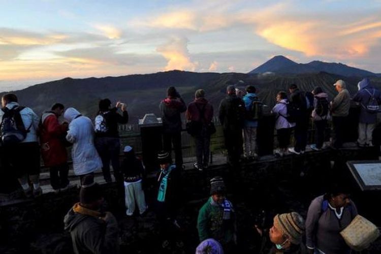 Wisatawan menikmati keindahan pagi kawasan Gunung Bromo dari atas Gunung Penanjakan, Pasuruan, Jawa Timur, Selasa (23/4/2013). Gunung Bromo masih menjadi tujuan wisata utama di Jawa Timur dengan jumlah pengunjung rata-rata 10.000 orang per bulan.

