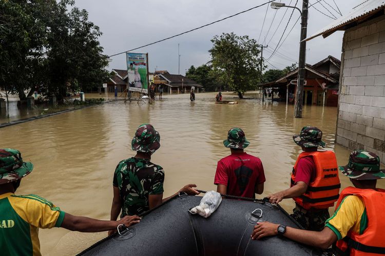 Petugas dari TNI angkatan Darat melakukan evakuasi terhadap warga yang terdampak banjir di Desa Karangligar, Kecamatan Telukjambe Barat, Karawang, Jawa Barat, Rabu (10/2/2021). Banjir di Karawang meluas ke 30 desa di 17 kecamatan. Akibatnya sebanyak 3.396 orang mengungsi dan satu orang meninggal dunia.