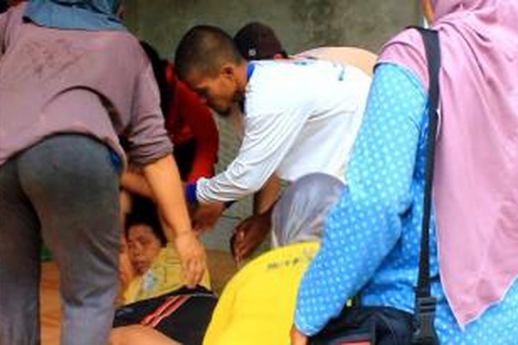 Para tetangga berusaha menggotong Errah yang menangis histeris mendengar anaknya tewas terbakar di kamar tidur, di Blok Gunung Santri, Desa Kepuh, Kecamatan Palimanan, Kabupaten Cirebon, Jawa Barat, Selasa (23/12/2014).