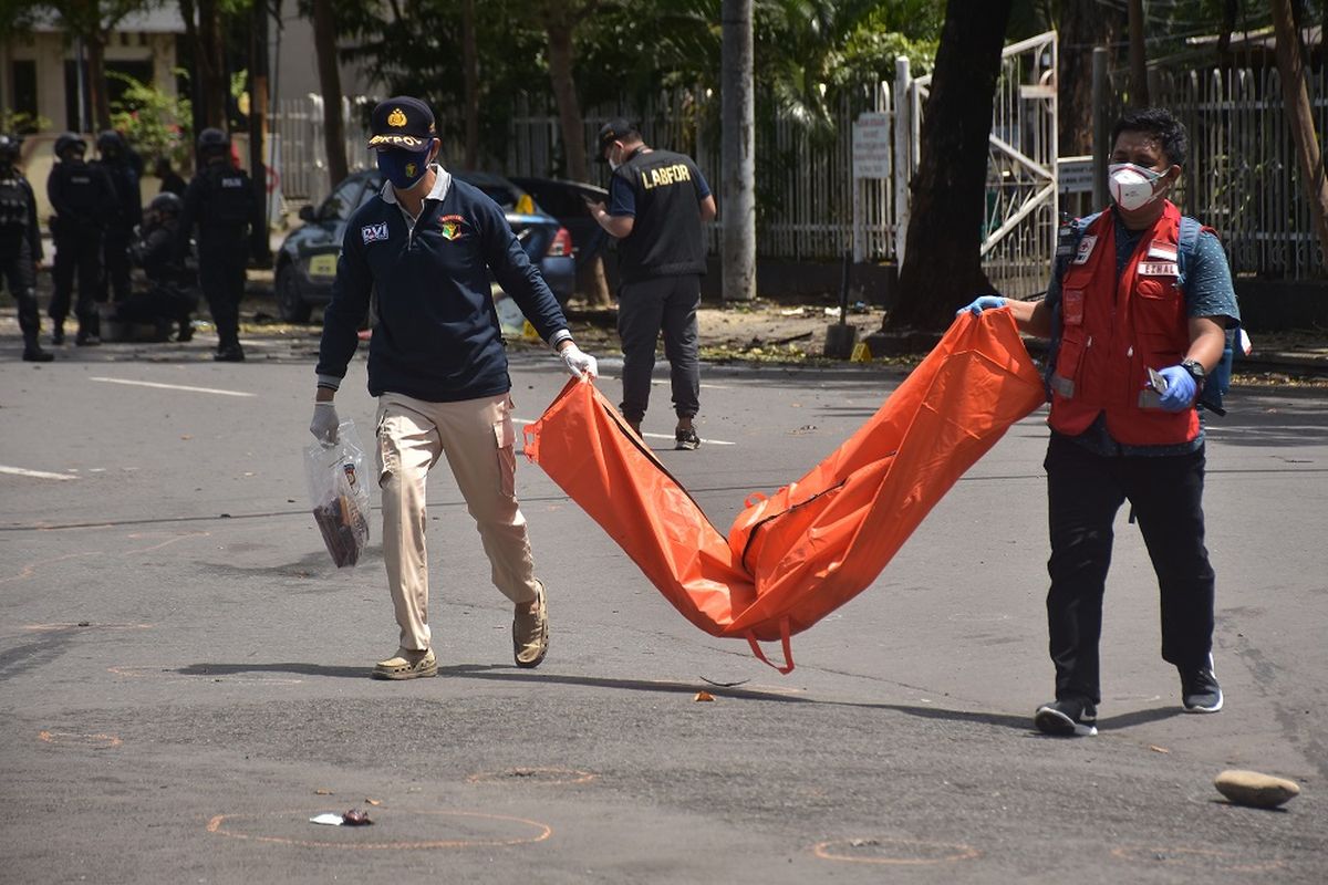 Petugas mengangkat kantong jenazah berisi bagian tubuh dari terduga pelaku bom bunuh diri di depan Gereja Katedral Makassar, Sulawesi Selatan, Minggu (28/3/2021). Bagian tubuh jenazah tersebut selanjutnya dibawa ke Rumah Sakit Bhayangkara Makassar untuk diidentifikasi. ANTARA FOTO/Indra Abriyanto/AP/wsj.