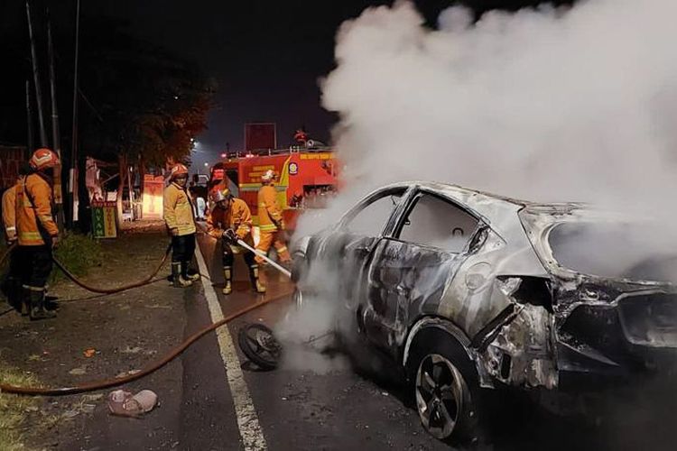 Petugas Damkarla Gresik dari Pos Driyorejo saat melakukan pemadaman api yang membakar kendaraan, usai terlibat tabrakan di Jalan Raya Petiken, Kecamatan Driyorejo, Gresik, Jawa Timur, Kamis (2/3/2023).