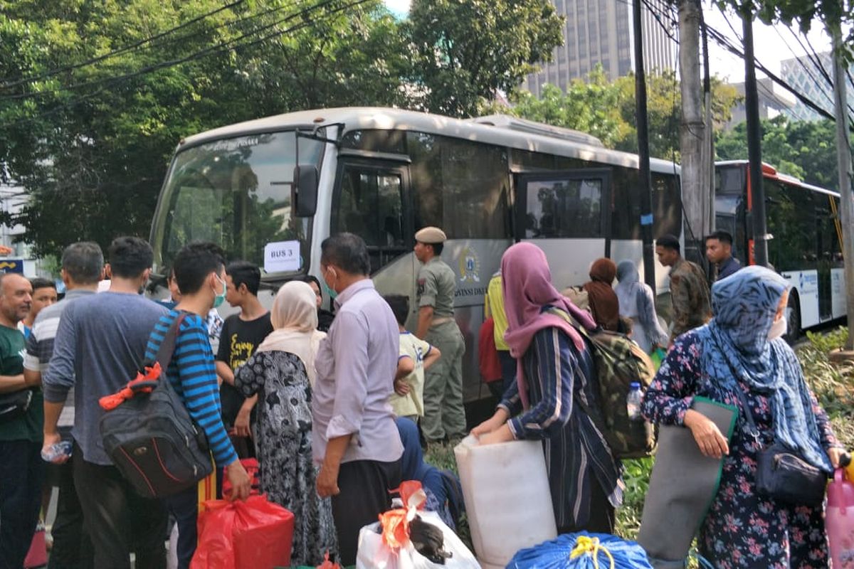 Para pencari suaka yang sudah berhari-hari menetap di trotoar Jalan Kebon Sirih, Jakarta Pusat, bersiap-siap untuk dipindahkan ke Lapangan Eks Kodim di Kalideres, Jakarta Barat, Kamis (11/7/2019).