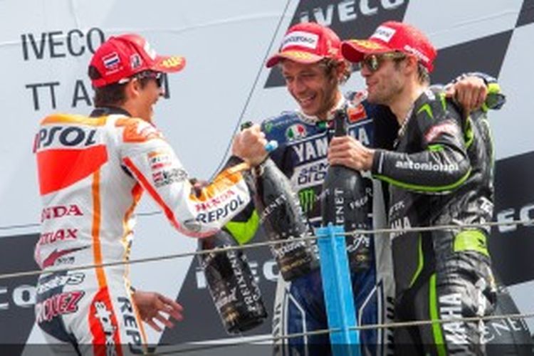 Pebalap Italia, Valentino Rossi (tengah) merayakan kemenangannya bersama Marc Marquez (kiri) dan Cal Crutchlow di podium GP Belanda, Sabtu (29/6/2013).