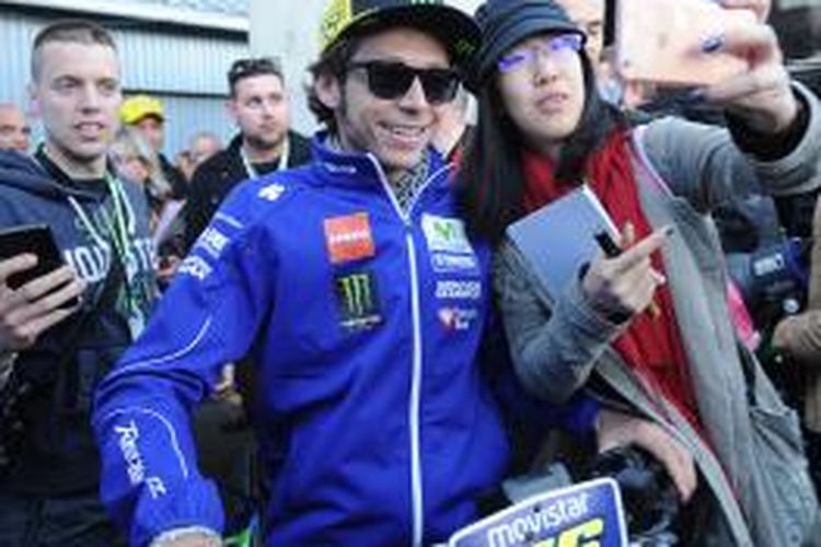 Pebalap Movistar Yamaha asal Italia, Valentino Rossi, berfoto bersama penggemar di Sirkuit Le Mans, Perancis, Kamis (14/5/2015).