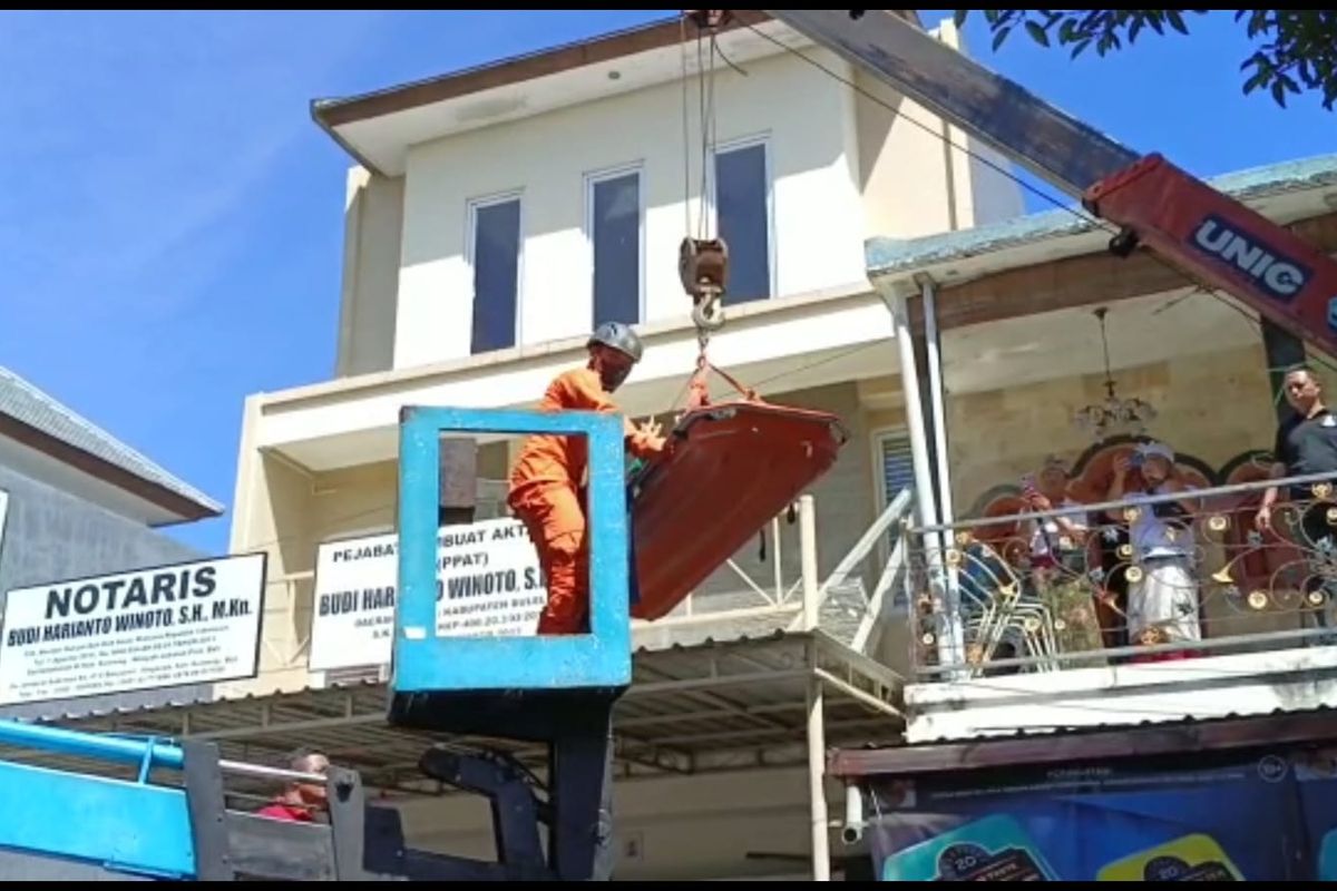 Petugas mengevakuasi pria penderita ovesitas dari lantai dua menggunakan sky lift di Kelurahan Banyuasri, Kecamatan Buleleng, Kabupaten Buleleng, Provinsi Bali, Senin (17/7/2023).