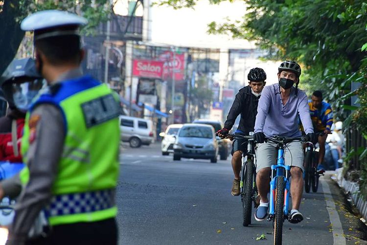 Polisi memutar balik pesepeda yang masih nekat gowes saat hari kedua pemberlakuan pembatasan kegiatan masyarakat (PPKM) darurat di Kota Bandung, Jawa Barat, Minggu (4/7/2021). Kegiatan memutar balik pesepeda tersebut sesuai dengan Perwal No 68 tahun 2021, berdasarkan Pasal 9 ayat 4 yakni pembatasan mobilitas orang untuk mencegah penyebaran Covid-19 pada masa PPKM darurat.