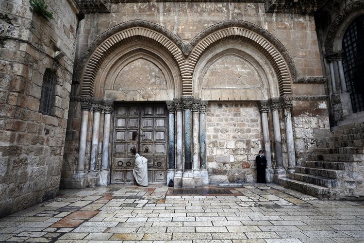Seorang pria berdiri di depan pintu Gereja Makam Yesus pada Jumat Agung, di tengah pandemi virus corona yang sedang berlangsung. Foto diambil di Yerusalem pada 10 April 2020.