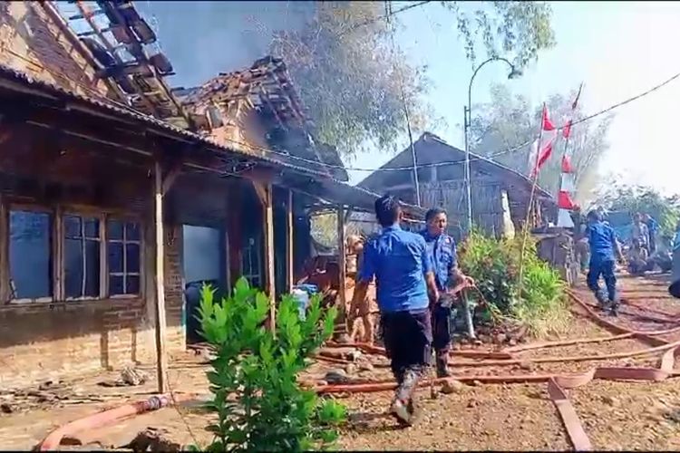Petugas Pemadam Kebakaran Pemkab Ponorogo berupaya memadamkan api yang menghanguskan dua rumah warga Dusun Sukun, Desa Sidoharjo, Kecamatan Pulung, Kabupaten Ponorogo, Jawa Timur, Senin (21/8/2023).