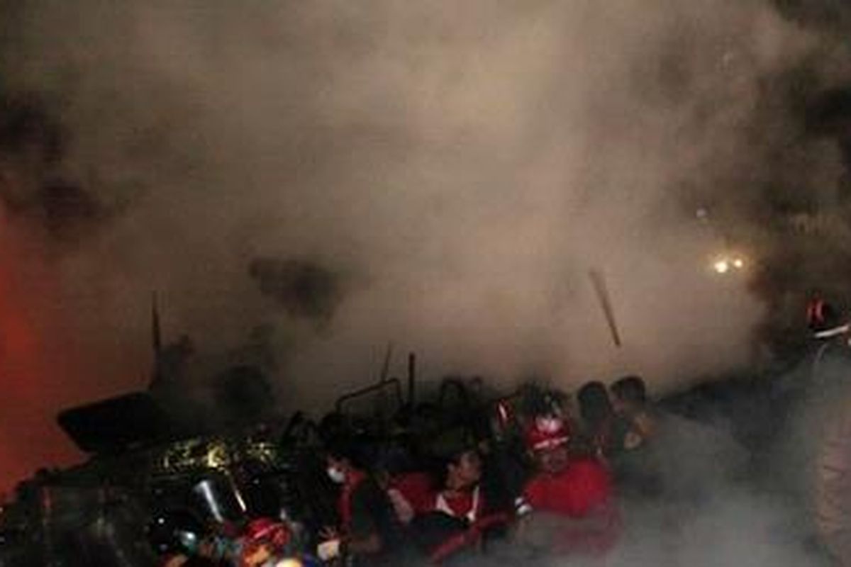 Demonstran antipemerintah menghindari diri dari gas air mata selama terlibat bentrokan dengan pasukan keamanan Thailand di Bangkok, 10 April 2010 