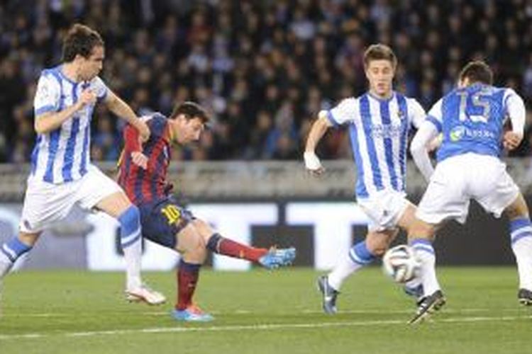 Penyerang Barcelona, Lionel Messi (kedua dari kiri), melepaskan tembakan yang berujung gol ke gawang Real Sociedad, pada leg kedua semifinal Copa del Rey, di Anoeta, Rabu (12/2/2014).