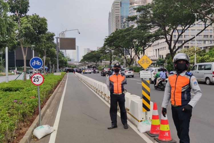 Petugas dari Dinas Perhubungan menjaga jalur sepeda permanen Sudirman, Selasa (6/4/2021).