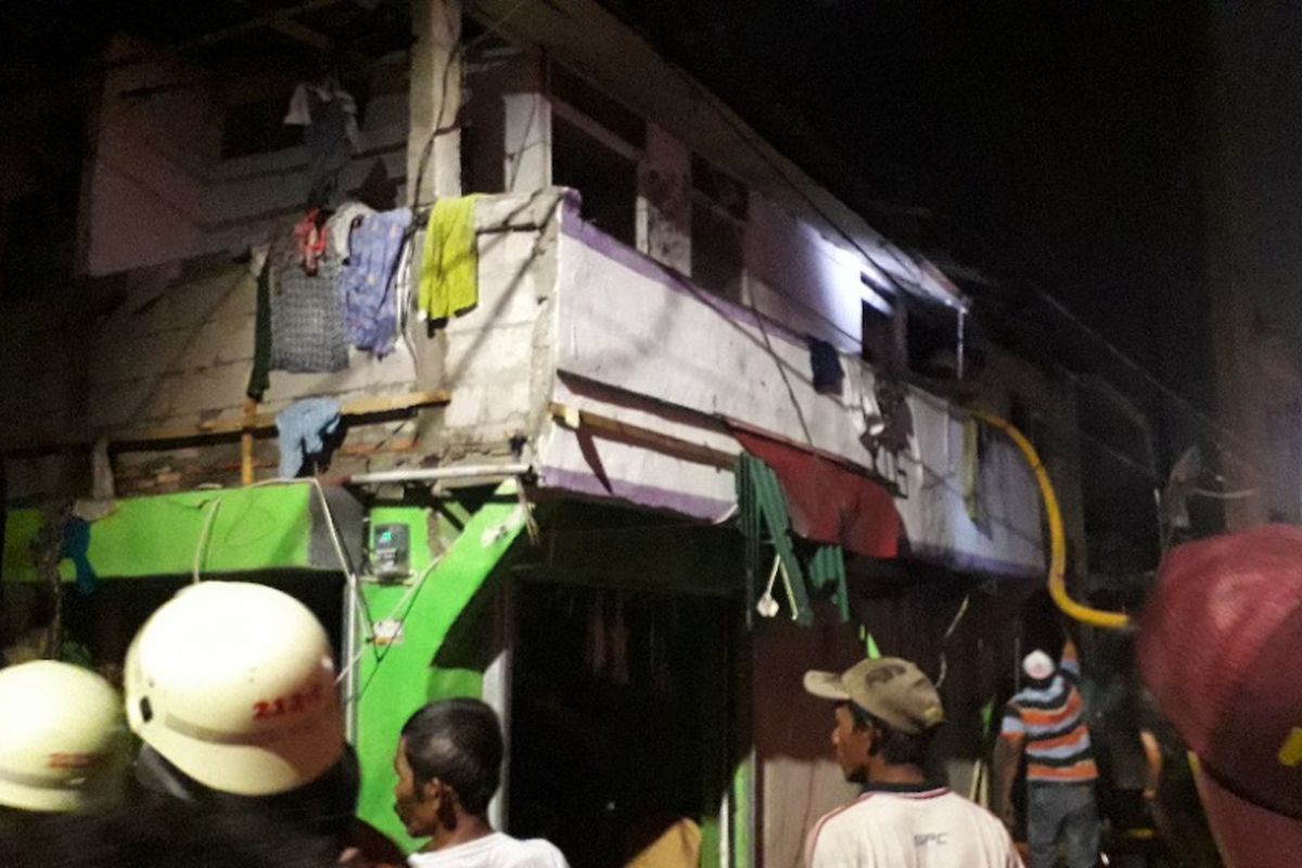 Petugas bersama warga berupaya memadamkan api yang menghanguskan dua rumah di Pademangan Barat, Jakarta Utara, 