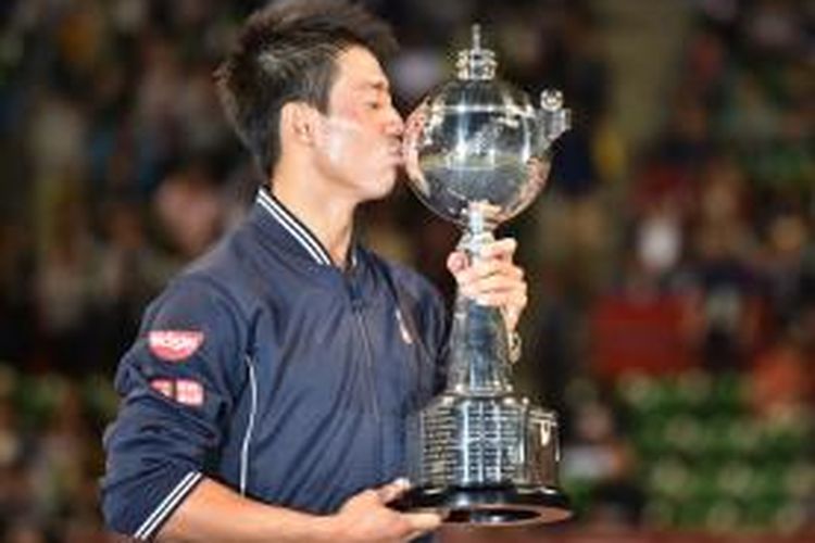 Petenis Jepang, Kei Nishikori, mencium trofi juara Jepang Terbuka yang didapat setelah mengalahkan Milos Raonic (Kanada) di final, Minggu (5/10/2014). Nishikori menang 7-6 (7/5), 4-6, 6-4.